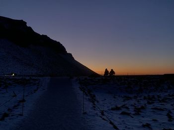 Silhouette people against sky at sunset during winter