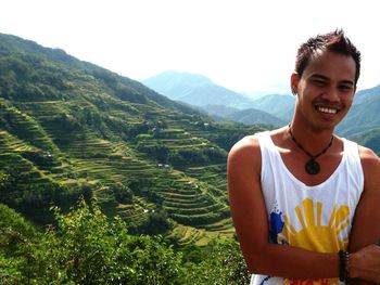 Portrait of happy man standing against banaue rice terraces