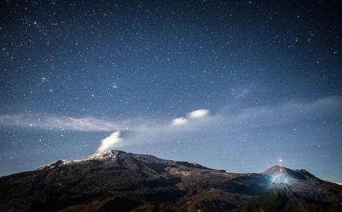 Scenic view of majestic mountains against sky at night