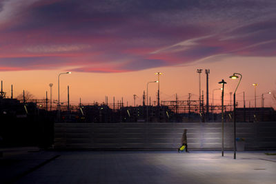 Silhouette street against sky at sunset