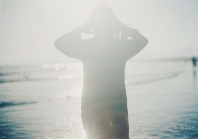 Close-up of man standing at beach against sky
