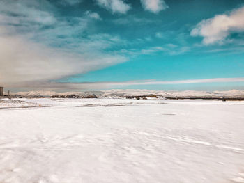 Snow covered land against sky