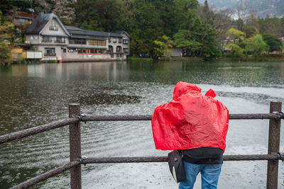 Rear of sad boy in red raincoat failed when visit  kinrin lake with rain, yufuin, oita, japan. 