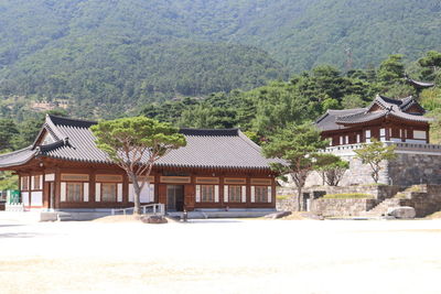 Built structure by sea against mountain