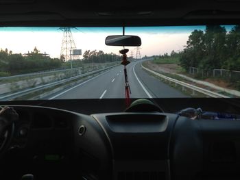 Cars moving on road seen through car windshield