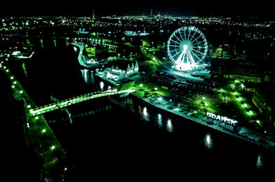 Illuminated ferris wheel in city at night