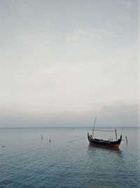 Fishing boat in sea against sky