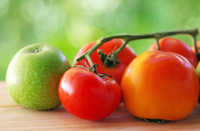 Close-up of tomatoes and apple on table