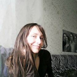 Portrait of smiling young woman sitting at home