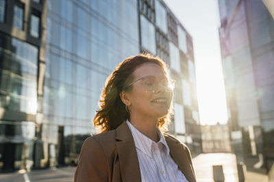 Smiling businesswoman day dreaming with eyes closed