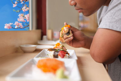 Midsection of woman eating food at home