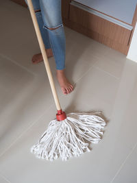 Low section of woman cleaning floor