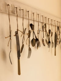 Close-up of cutlery hanging against wall