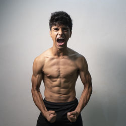 Portrait of shirtless man against white background