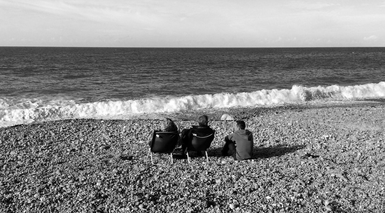 sea, water, horizon over water, leisure activity, lifestyles, men, sky, beach, tranquil scene, scenics, sitting, nature, person, beauty in nature, tranquility, shore, relaxation