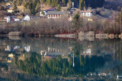 Scenic view of lake by trees and buildings