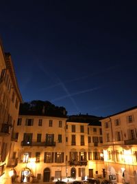 Low angle view of illuminated buildings against sky at night