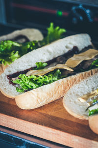 Sandwich in the making. fresh buns with sauces, beef cheese and letucce. 