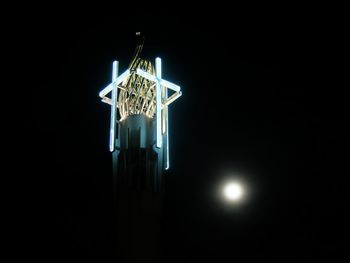 Low angle view of illuminated lamp against black background