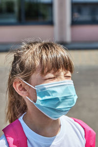 Close-up portrait of a girl with a protective medical mask. vertical photo. protecting students 