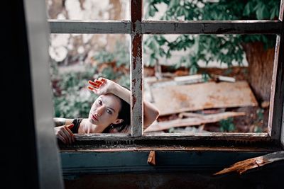 Young woman lying on window