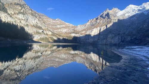 Scenic view of lake and mountains against blue sky