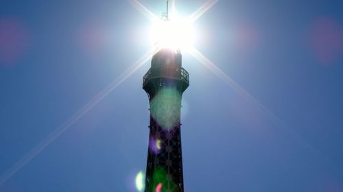 Low angle view of sun shining through clouds