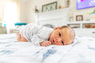 Portrait of boy lying on bed at home