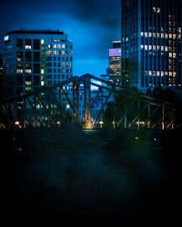 Illuminated buildings against sky at night in city