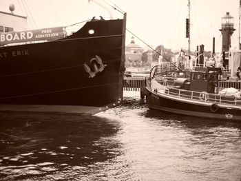 Boats moored at harbor against sky