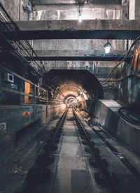 Railroad tracks in illuminated tunnel