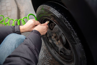 Men's hands hold a pump for a car tire