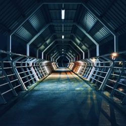 Empty illuminated walkway of bridge