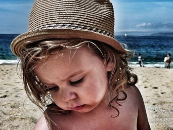 Close-up of girl on beach against sky