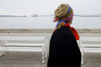 Rear view of woman standing against sea