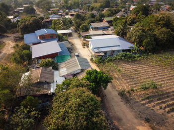High angle view of houses amidst trees and buildings