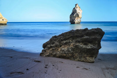 Scenic view of rocks on beach against sky