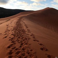 Sand dunes in desert against sky