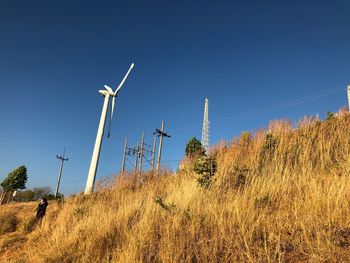 Low angle view of wind turbines against sky