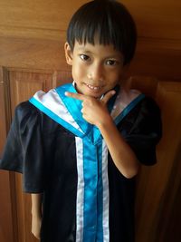 Portrait of smiling boy wearing graduation gown