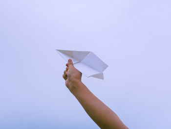 Person holding paper against white background