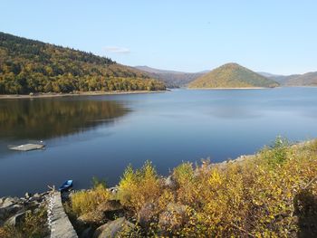 Scenic view of lake by trees against sky