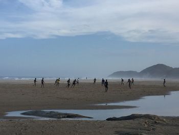 People on beach against sky