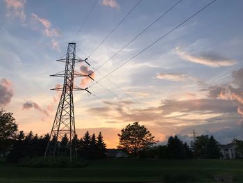 Silhouette trees on field against sky during sunset