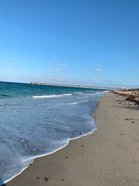 Scenic view of beach against blue sky