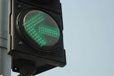 Low angle view of road signal against sky