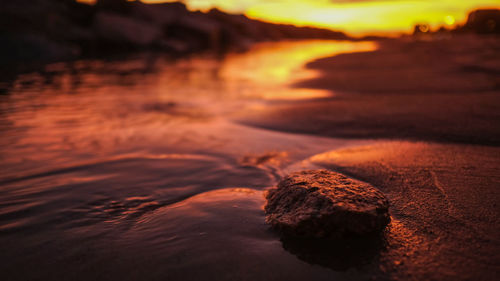 Surface level of rocks against sky at sunset