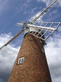 Low angle view of windmill against cloudy sky