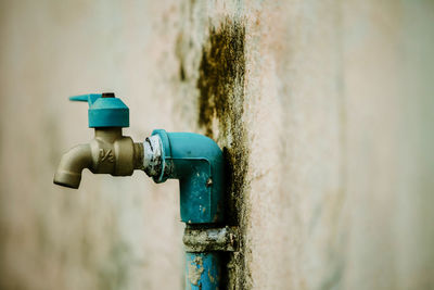 Close-up of faucet attached on old wall