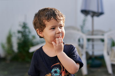 Little boy playing with a watering hose in the backyard